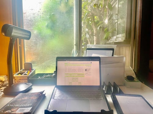 picture of computer on desk looking out to window where student studies