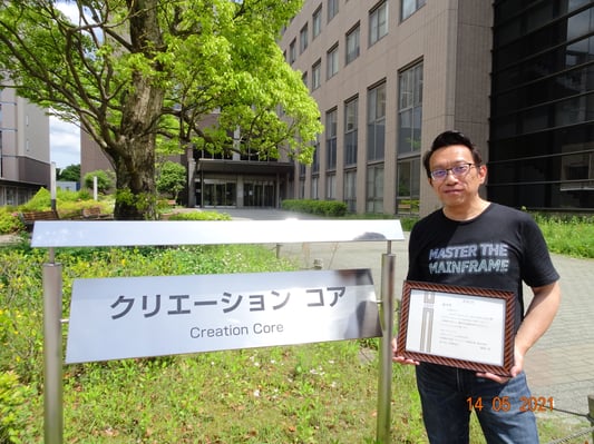 Zam, in front of Creation Core at ISSE with his T-Shirt and Certificate