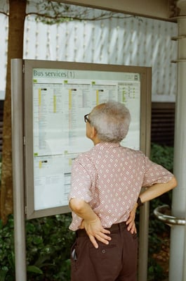 old man looking at timetable