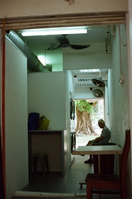 elderly man resting on chair in alley